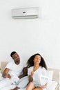 African american man looking at sweaty woman in room