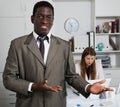 African american man manager welcoming to office, woman colleague working