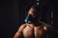 African american man in mask looking at camera with angry sight close-up in gym. black men and black background