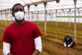 African american man in medical mask in greenhouse