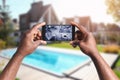 African-American man monitoring CCTV cameras on smartphone near his house, closeup. Home security system Royalty Free Stock Photo