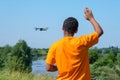 African American man operating drone with controller on the meadow with back Royalty Free Stock Photo