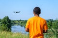 African American man operating drone with controller on the meadow with back Royalty Free Stock Photo