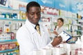 African American man pharmacy chemist making notes on clipboard