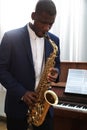 African-American man playing saxophone indoors. Talented musician Royalty Free Stock Photo