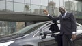 African-American man pleased that fulfilled his dream and bought luxury car