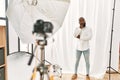 African american man posing as model at photography studio serious face thinking about question with hand on chin, thoughtful Royalty Free Stock Photo