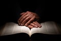 African American Man Praying with Hands on Top of the Bible Royalty Free Stock Photo