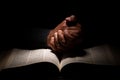 African American Man Praying with Hands on Top of the Bible Royalty Free Stock Photo