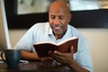 African American man praying and reading the Bible.