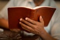 African American man praying and reading the Bible.