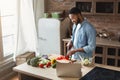 African-american man preparing salad in loft kitchen Royalty Free Stock Photo