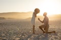 An African American man proposing to the woman on beach on a sunny day Royalty Free Stock Photo