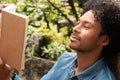 African american man reading book in park Royalty Free Stock Photo