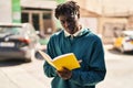 African american man reading book at street Royalty Free Stock Photo