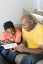 African American man reading with his son.