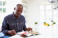 African American Man Reading Magazine At Home Royalty Free Stock Photo