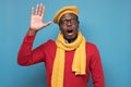 African american man in red sweater, yellow scarf and hat counting five fonger.