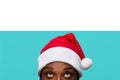 African-American man in a Santa Claus hat with expressive eyes looks up attentively