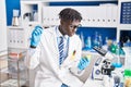 African american man scientist holding pill and lemon at laboratory Royalty Free Stock Photo