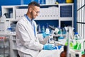 African american man scientist smiling confident weighing pills at laboratory Royalty Free Stock Photo