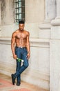 Young black man holding white rose, standing outdoors in New York City, looking forward Royalty Free Stock Photo