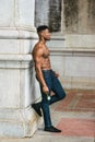 Young black man holding white rose, standing outdoors in New York City, looking forward, thinking Royalty Free Stock Photo