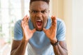 African american man shouting with rage, yelling excited with hand on mouth Royalty Free Stock Photo