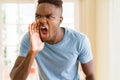 African american man shouting with rage, yelling excited with hand on mouth Royalty Free Stock Photo