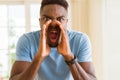 African american man shouting with rage, yelling excited with hand on mouth Royalty Free Stock Photo
