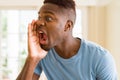 African american man shouting with rage, yelling excited with hand on mouth Royalty Free Stock Photo