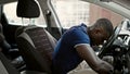 African american man sitting on car tired with head on steering wheel at street Royalty Free Stock Photo