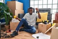 African american man sitting on the floor at new home dancing happy and cheerful, smiling moving casual and confident listening to Royalty Free Stock Photo