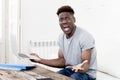 African american man sitting at home living room working with laptop computer and paperwork Royalty Free Stock Photo