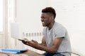 African american man sitting at home living room working with laptop computer and paperwork Royalty Free Stock Photo