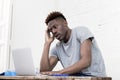 African american man sitting at home living room working with laptop computer and paperwork Royalty Free Stock Photo