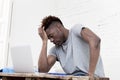 African american man sitting at home living room working with laptop computer and paperwork Royalty Free Stock Photo