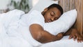 African Man Sleeping Hugging Pillow Lying In Bed At Home