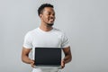 African American man smiling and showing laptop with blank screen Royalty Free Stock Photo