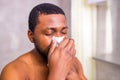 african american man snot symptom feeling bad stay at home looking at mirrror in bathroom