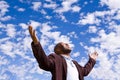 African American man stading outside with open arms.