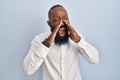 African american man standing over blue background shouting angry out loud with hands over mouth Royalty Free Stock Photo