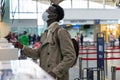 African American man stands at check-in counters at the airport terminal, giving passport to an officer. Flight rules during a
