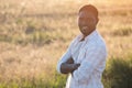 African American man stands smiling against wheat plantation