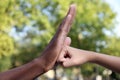 African American man stopping woman`s fist outdoors, closeup. Antiracism concept