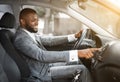 African man driver turning on music in car before moving