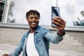 African American man takes a selfie on the street, in front of a glass building, traveling alone Royalty Free Stock Photo