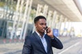 African American man talking on a cell phone near the airport, businessman arrived on a business trip Royalty Free Stock Photo