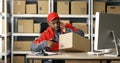 African American man talking on mobile phone while working at post office store and on computer. Postman scanning bar