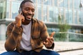 African american man talking on smartphone on street in city outdoor. Man with cell phone chatting with friends. Smiling Royalty Free Stock Photo